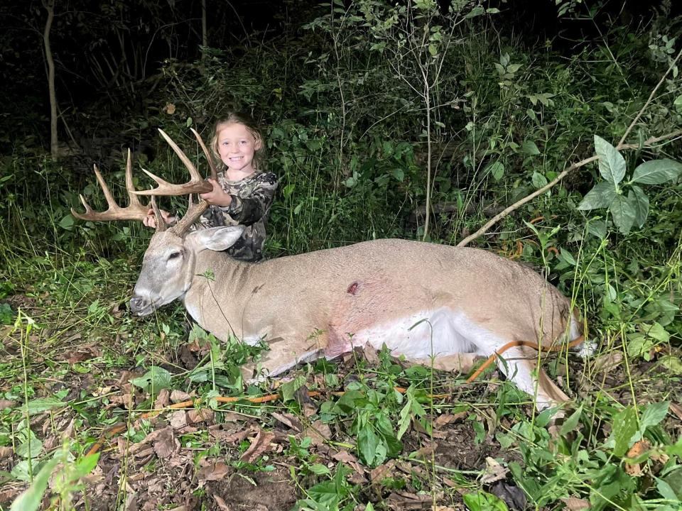 A young girl sits behind a nice Indiana buck.