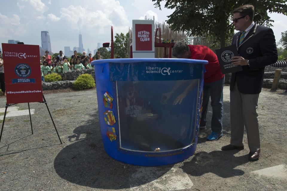 North American Speed Cube Champion Anthony Brooks attempts to break the Guinness World Records title for "Most Cubes Solved Underwater In One Breath" at the National Rubik's Cube Championship at Liberty Science Center in Jersey City