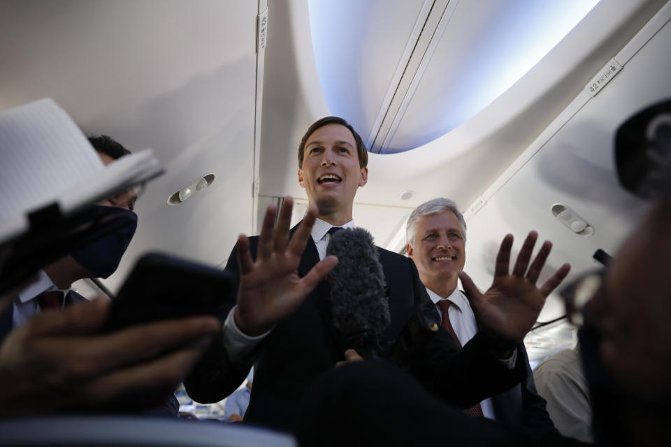 U.S. President Donald Trump's senior adviser Jared Kushner, center, stands with U.S. National Security Advisor Robert O'Brien while speaking to journalists during a flight on an Israeli El Al plane to Abu Dhabi, United Arab Emirates, Monday, Aug. 31, 2020. The plane landed in Abu Dhabi after flying in from Israel in the first-ever direct commercial passenger flight to the United Arab Emirates. (Nir Elias/Pool Photo via AP)