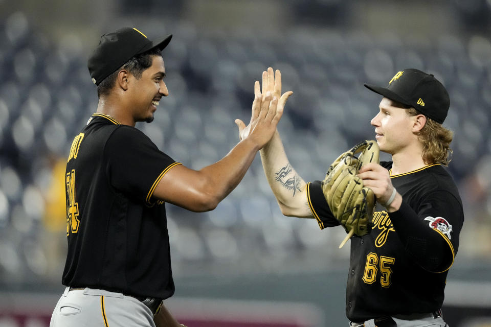 Pittsburgh Pirates starting pitcher Johan Oviedo, left, celebrates with right fielder Jack Suwinski (65) after their baseball game against the Kansas City Royals Monday, Aug. 28, 2023, in Kansas City, Mo. Oviedo pitched a complete game leading the Pirates to a 5-0 win. (AP Photo/Charlie Riedel)