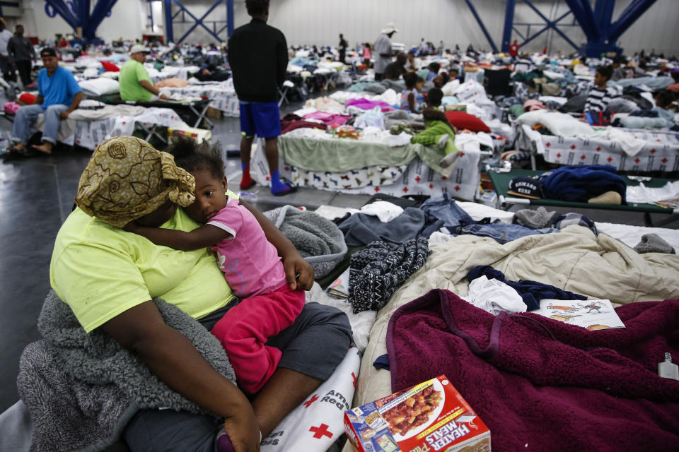 Quinisha Runnels holds her cousin, Mimi Runnels, 2, on a cot at the George R. Brown Convention Center where nearly 10,000 people are taking shelter after Tropical Storm Harvey Wednesday, Aug. 30, 2017 in Houston. ( Photo: Michael Ciaglo / Houston Chronicle/AP)