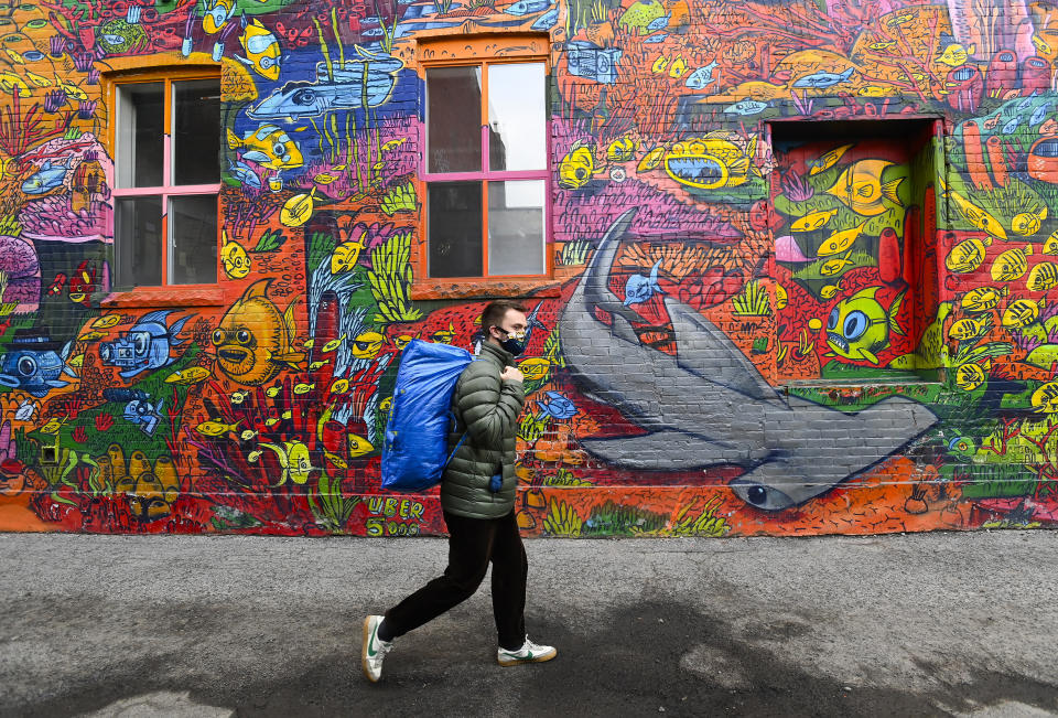 A person walks past a nature mural on Earth Day during the COVID-19 pandemic in Toronto, Thursday, April 22, 2021. (Nathan Denette/The Canadian Press via AP)