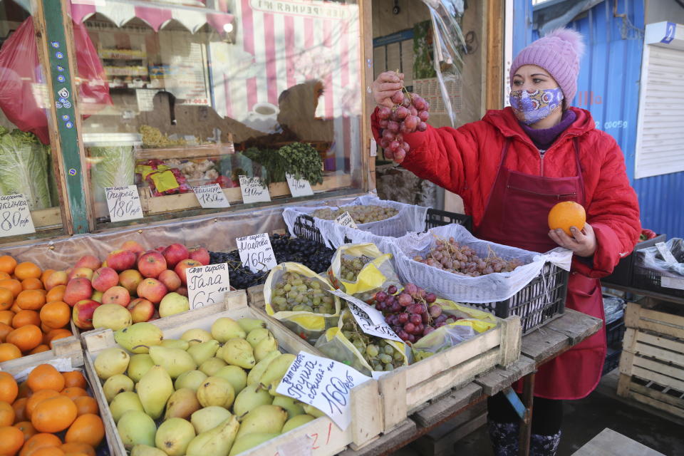 A fruit seller at a street market in Donetsk, the territory controlled by pro-Russian militants, eastern Ukraine, Feb. 14, 2022. Amid fears of a Russian invasion of Ukraine, tensions have also soared in the country’s east, where Ukrainian forces are locked in a nearly eight-year conflict with Russia-backed separatists. A sharp increase in skirmishes on Thursday raised fears that Moscow could use the situation as a pretext for an incursion. (AP Photo/Alexei Alexandrov)