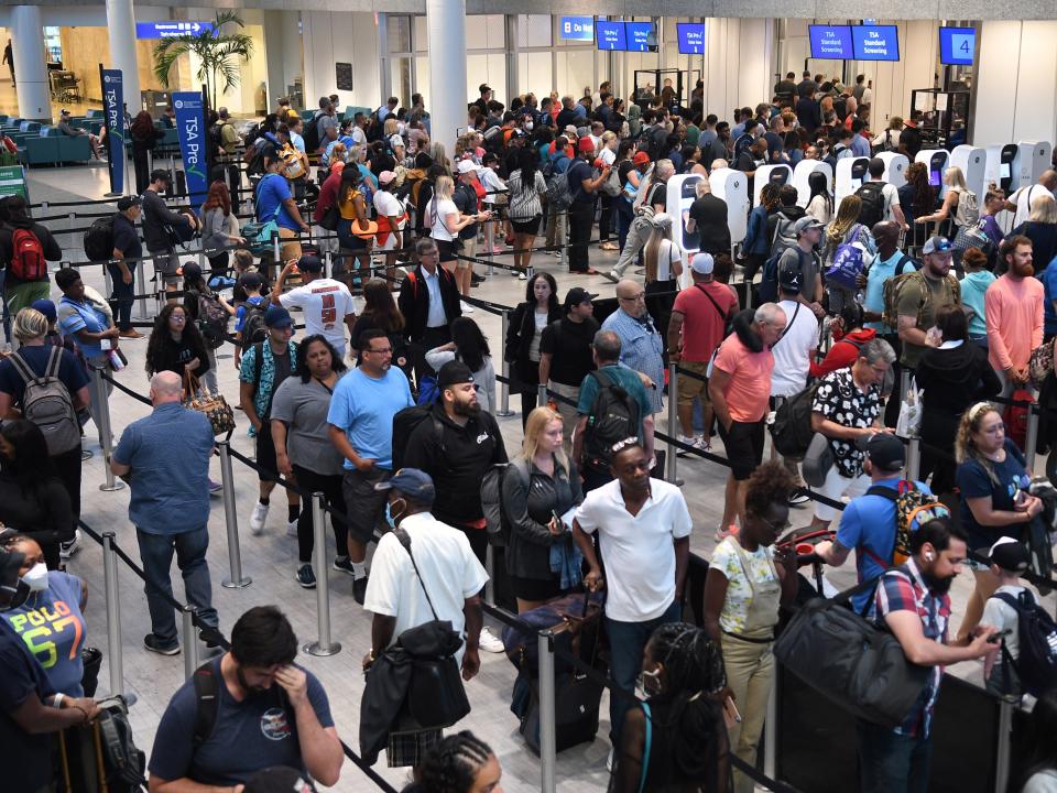 Travelers make their way through a TSA screening line at Orlando International Airport ahead of the July 4 holiday