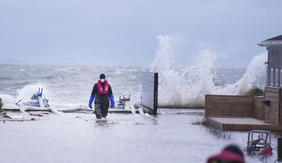 A man walks in a flooded neighborhood in Haderslev, Denmark, Friday, Oct. 20. 2023. Authorities across Scandinavia on Friday urged vigilance as the region braced for heavy rain and gale-force winds from the east that was expected to culminate in the evening as a severe storm continued to sweep across northern Europe. The gale-force winds are expected to hit hardest in the eastern part of Denmark's Jutland peninsula and the Danish islands in the Baltic Sea. (Claus Fisker/Ritzau Scanpix via AP)