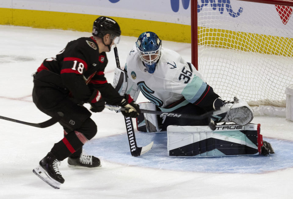 Seattle Kraken goaltender Joey Daccord (35) makes a save against Ottawa Senators center Tim Stutzle (18) during second-period NHL hockey game action, Saturday, Dec. 2, 2023, in Ottawa, Ontario. (Adrian Wyld/The Canadian Press via AP)