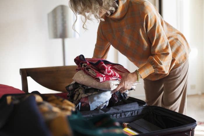 A woman packing a suitcase.