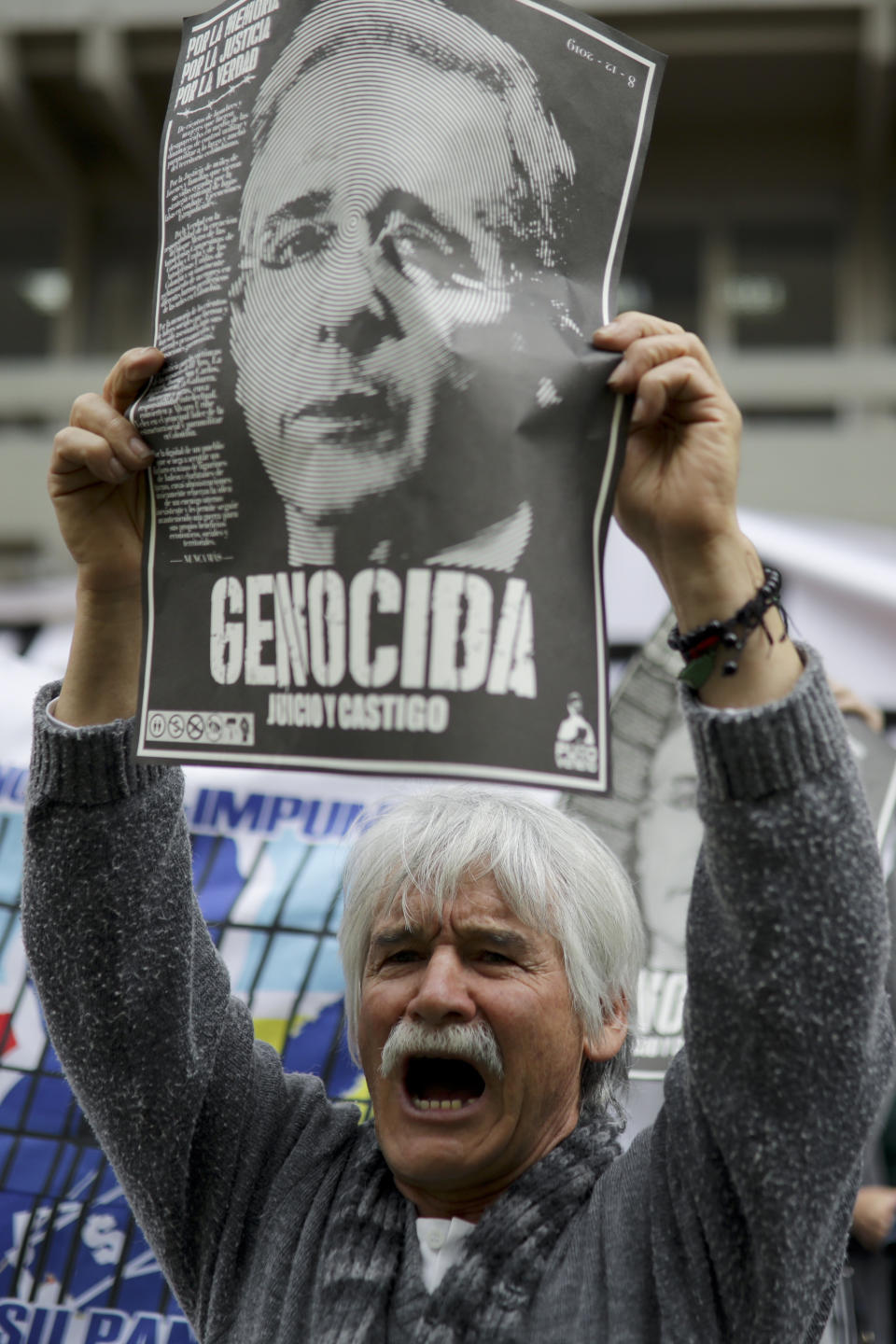 An opponent of former president Alvaro Uribe protests against him in front of the Supreme Court during Uribe’s hearing in an investigation for witness tampering, in Bogota, Colombia, Tuesday, Oct. 8, 2019. Uribe is being investigated for allegedly trying to influence and possibly bribe members of a former paramilitary group. (AP Photo/Ivan Valencia)