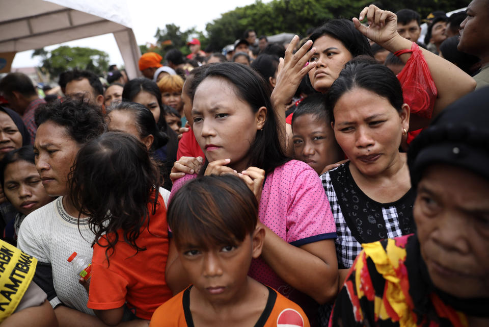 People queue up to receive food at an aid distribution point for those affected by the floods in Jakarta, Indonesia, Saturday, Jan. 4, 2020. Monsoon rains and rising rivers submerged parts of greater Jakarta and caused landslides in Bogor and Depok districts on the city's outskirts as well as in neighboring Lebak, which buried a number of people. (AP Photo/Dita Alangkara)