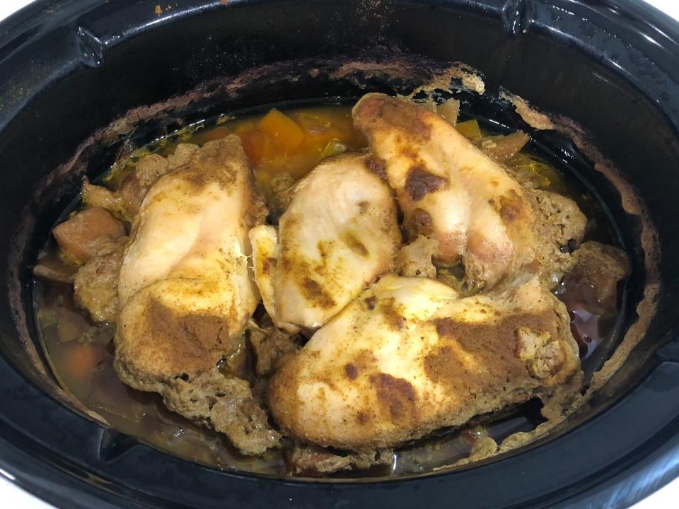 Chicken-and-vegetable curry cooks in a Crock-Pot with spices on top.