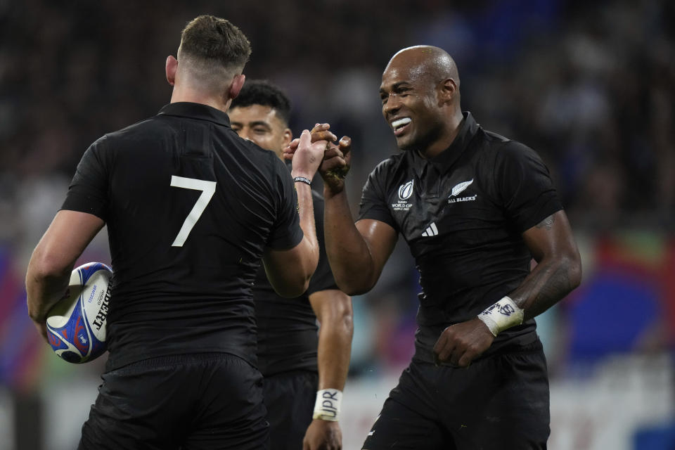 New Zealand's Dalton Papali'i, left, celebrates with teammate Mark Telea, after scoring a try during the Rugby World Cup Pool A match between New Zealand and Italy at the OL Stadium in Lyon, France, Friday, Sept. 29, 2023. (AP Photo/Pavel Golovkin)