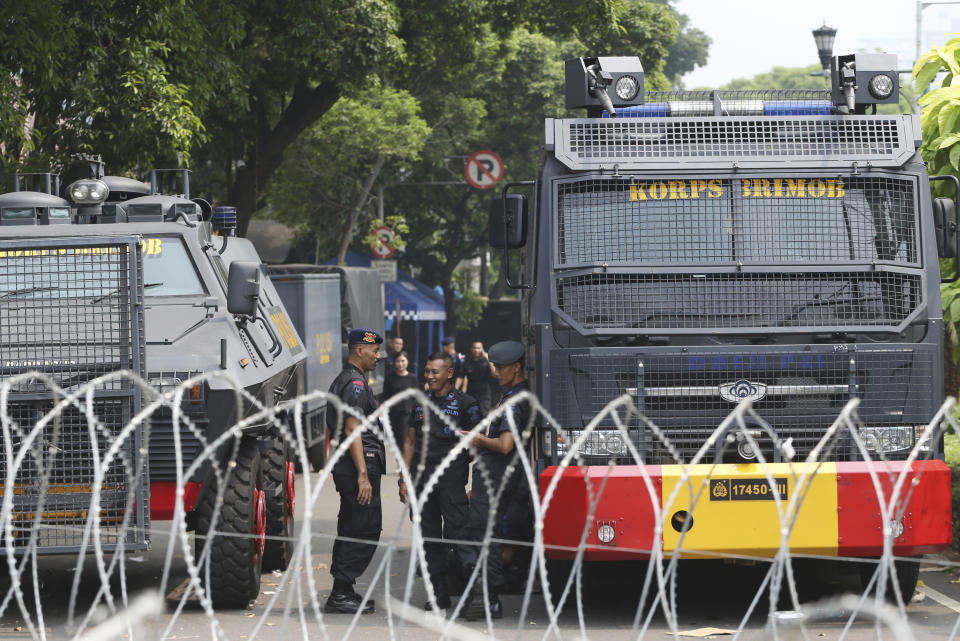 Indonesian police stand near water canon parked outside Election Commission building in Jakarta, Indonesia, Tuesday, May 21, 2019. Indonesia's President Joko Widodo has been elected for a second term, official results showed Tuesday, in a victory over a would-be strongman who aligned himself with Islamic hardliners. Thousands of police and soldiers are on high alert in the capital Jakarta, anticipating protests from Widodo's challenger Prabowo Subianto's supporters. (AP Photo/Achmad Ibrahim)