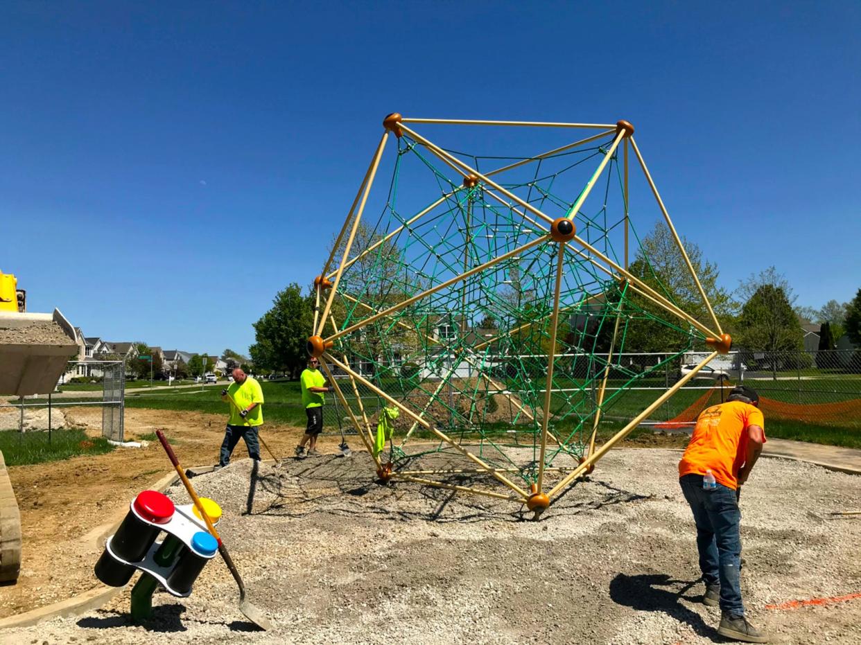 Workers with Midstates Recreation of Pataskala install a rubberized safety surface under a new climbing feature May 9 at Orange Township's Ro Park, 6804 Snapdragon Way.