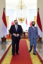 U.S. Secretary of State Mike Pompeo and Indonesian President Joko Widodo wearing protective masks walk during their meeting at the Presidential Palace in Bogor