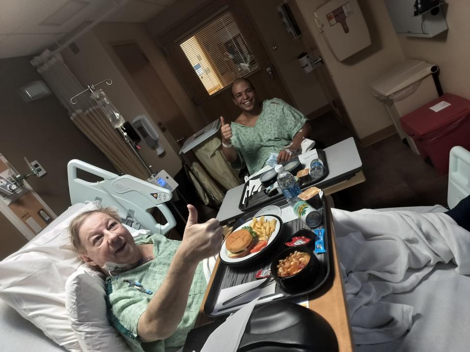 Joseph Reek, left, and his husband, Nilson DaSilva, have dinner together in Rhode Island Hospital two days after they had surgery for DaSilva to donate a kidney to Reek.