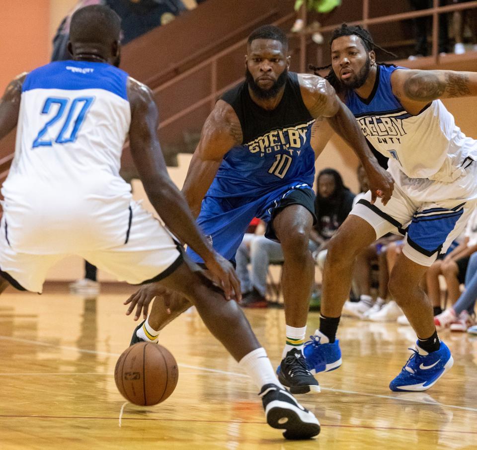 Shelby County Pro-Am blue team’s  Brandon Mitchell (10) is guarded by white team’s A.J. Jones (20) and K.J. Lawson (13) during a game Wednesday, July 20, 2022, at Orange Mound Community Center in Memphis. The Shelby County Pro-Am is a basketball league that features both current and former college and professional basketball players.