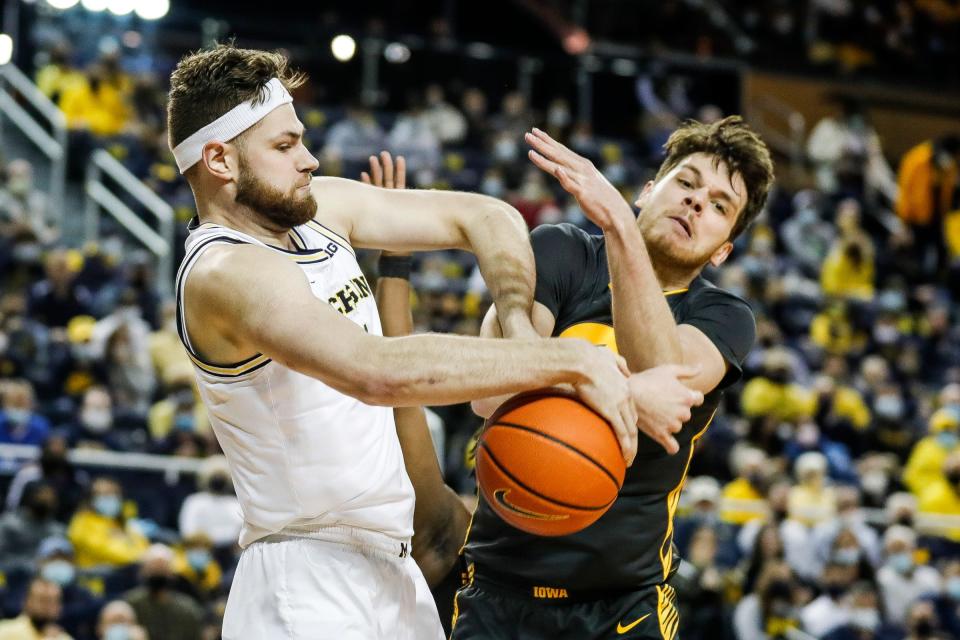 Michigan center Hunter Dickinson and Iowa forward Filip Rebraca battle for a rebound during the first half at the Crisler Center on Thursday, March 3, 2022.