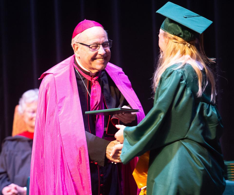 Bishop Felipe Estevez hands a St. Joseph Academy graduate her diploma during the school's 149th commencement ceremony at Flagler College, on Friday, June 3, 2022.