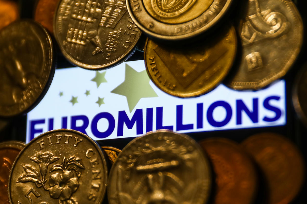 Euromillions logo displayed on a phone screen and coins are seen in this illustration photo taken in Krakow, Poland on June 14, 2022. (Photo illustration by Jakub Porzycki/NurPhoto via Getty Images)