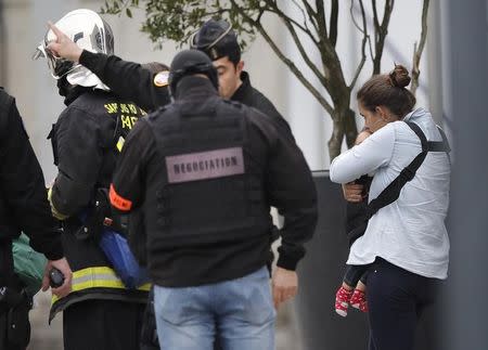 A woman carries a child out of Orly airport southern terminal after a shooting incident near Paris, France March 18, 2017. REUTERS/Benoit Tessier