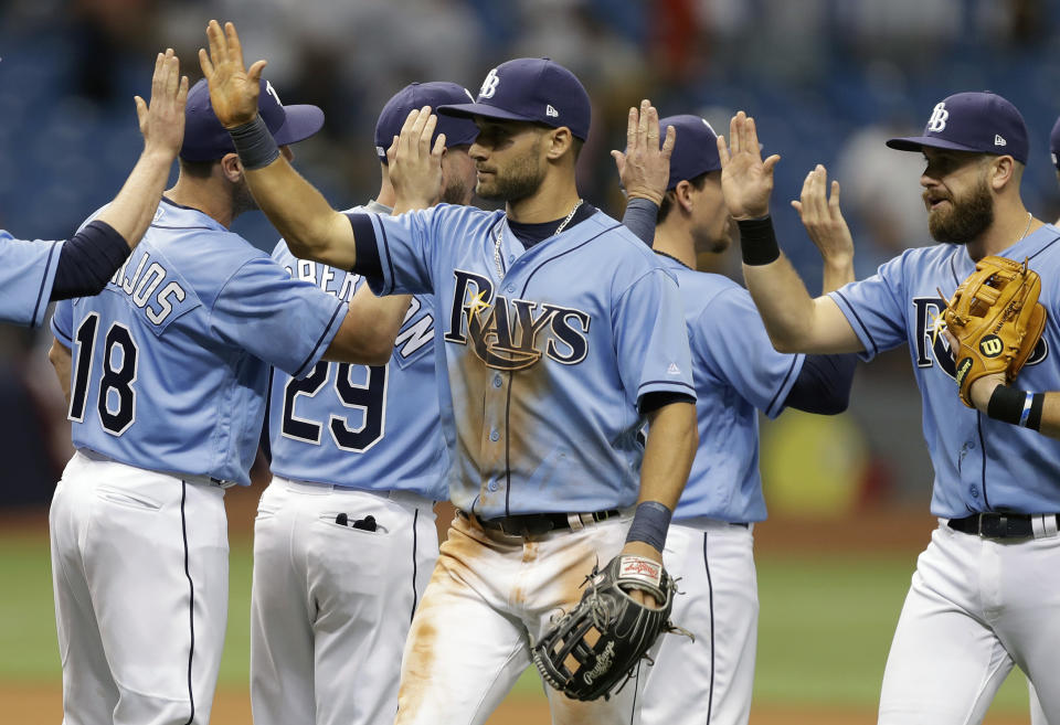 Tampa Bay Rays' Kevin Kiermaier, left, and third baseman Evan Longoria high-five teammates after the team defeated the New York Yankees in a baseball game Sunday, April 2, 2017, in St. Petersburg, Fla. (AP Photo/Chris O'Meara)