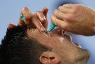 Novak Djokovic of Serbia puts eye drops in his eyes during break in his semifinal against Tommy Paul of the U.S. at the Australian Open tennis championship in Melbourne, Australia, Friday, Jan. 27, 2023. (AP Photo/Asanka Brendon Ratnayake)