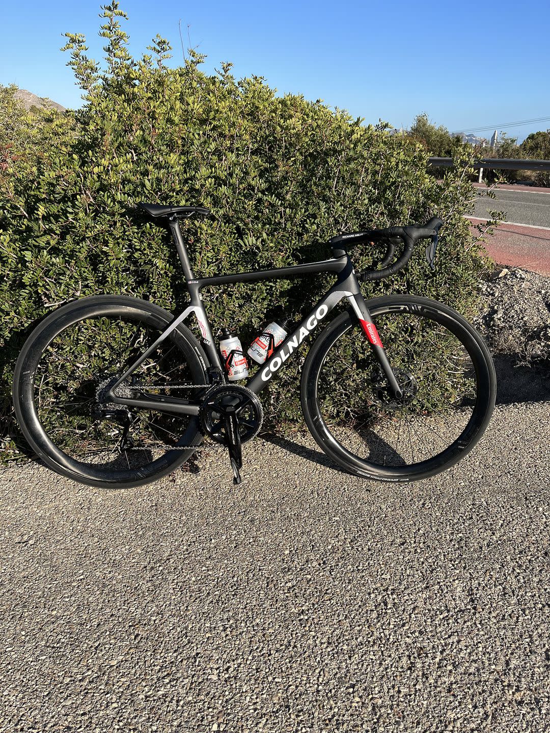 a black bicycle parked on gravel