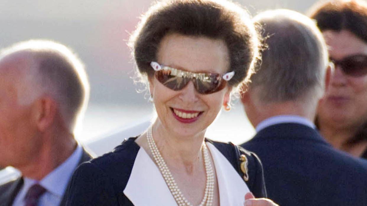 Princess Anne smiling in sunglasses and red lipstick