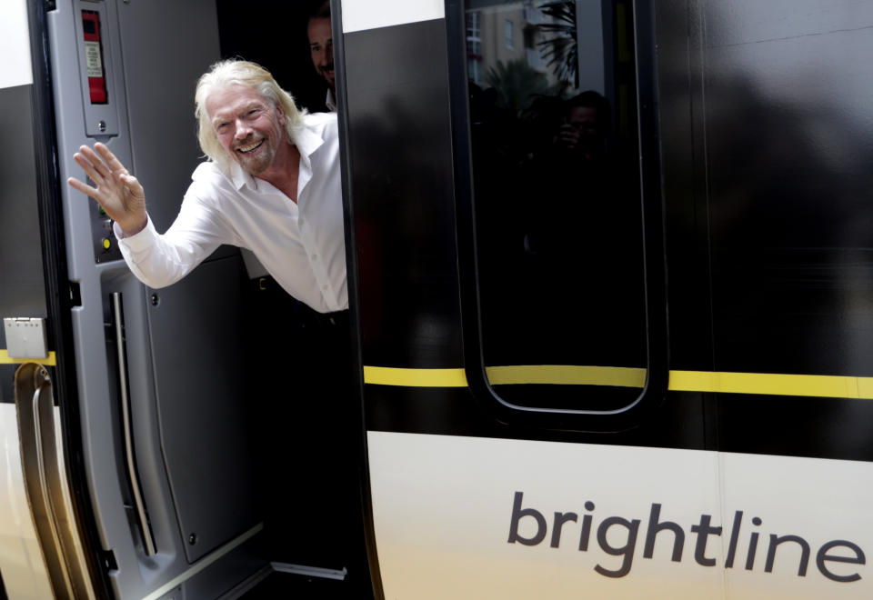 Richard Branson, of Virgin Group, waves as he arrives on a Brightline train, Thursday, April 4, 2019, in West Palm Beach, Fla. The state's Brightline passenger trains are being renamed Virgin Trains USA after Branson invested in the new fast-rail project that is scheduled to connect Miami with Orlando. (AP Photo/Lynne Sladky)