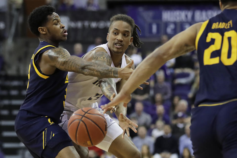 Washington forward Hameir Wright, center, passes the ball from between California guards Paris Austin, left, and Matt Bradley during the second half of an NCAA college basketball game Saturday, Feb. 22, 2020, in Seattle. Washington won 87-52. (AP Photo/Ted S. Warren)