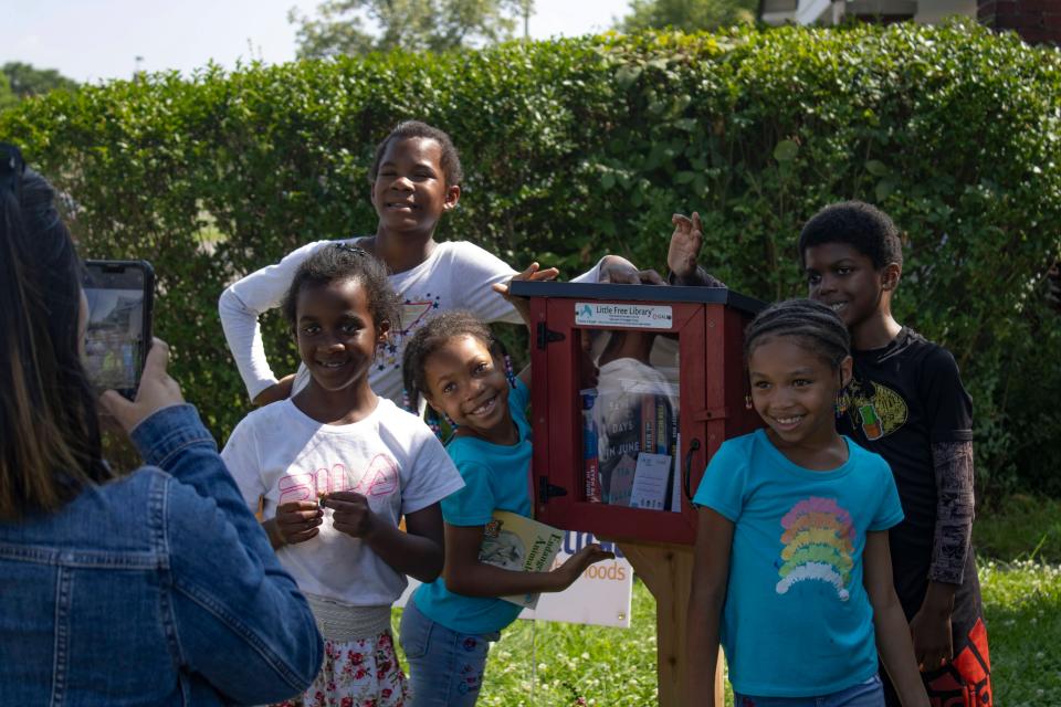 Some of the children pose by the new Little Library installed at Brilliant Detroit's Littlefield hub in Detroit, on Thursday, July 27, 2023.