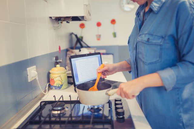 <p>Getty</p> woman cooking while working