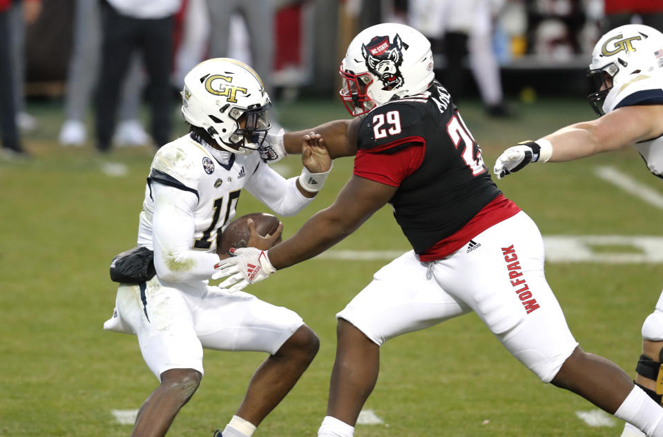 Georgia Tech quarterback Jeff Sims (10) escapes from North Carolina State defensive tackle Alim McNeill (29) during the first half of an NCAA college football game in Raleigh, N.C., Saturday, Dec. 5, 2020. (Ethan Hyman/The News & Observer via AP, Pool)