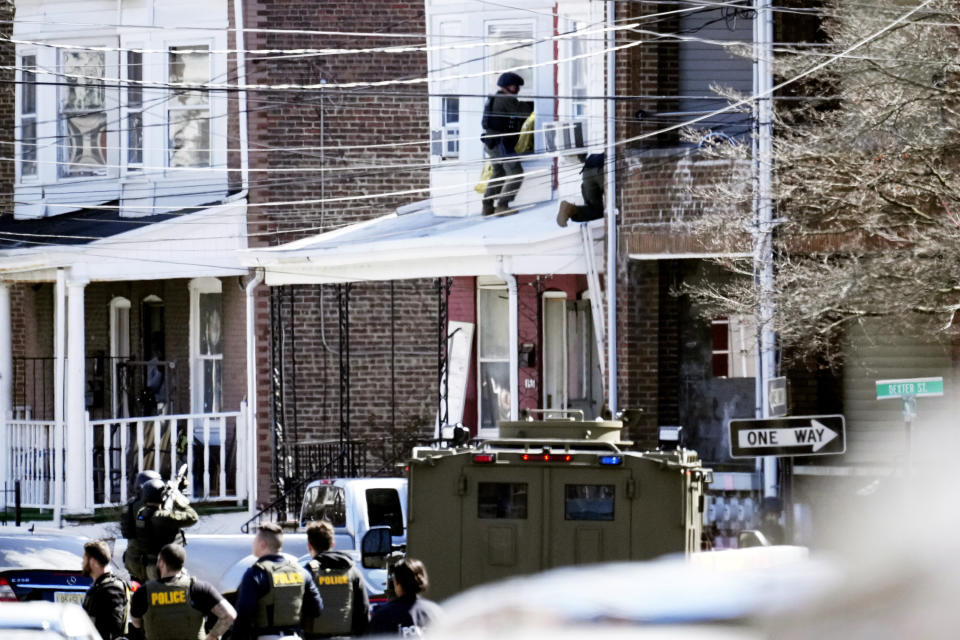 Police surround a home in Trenton, N.J., Saturday, March 16, 2024. A suspect has barricaded himself in the home and was holding hostages after shooting three people to death in suburban Philadelphia. (AP Photo/Matt Rourke)