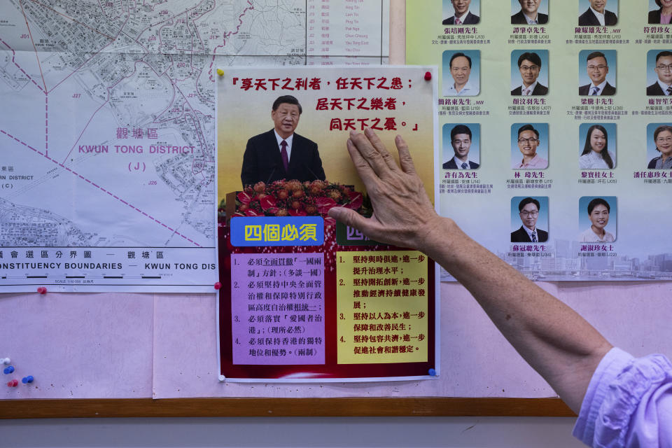 District councillor Winnie Poon presents a poster showing Chinese President Xi Jinping at her office during an interview with The Associated Press in Hong Kong, Wednesday, Nov. 29, 2023. (AP Photo/Louise Delmotte)