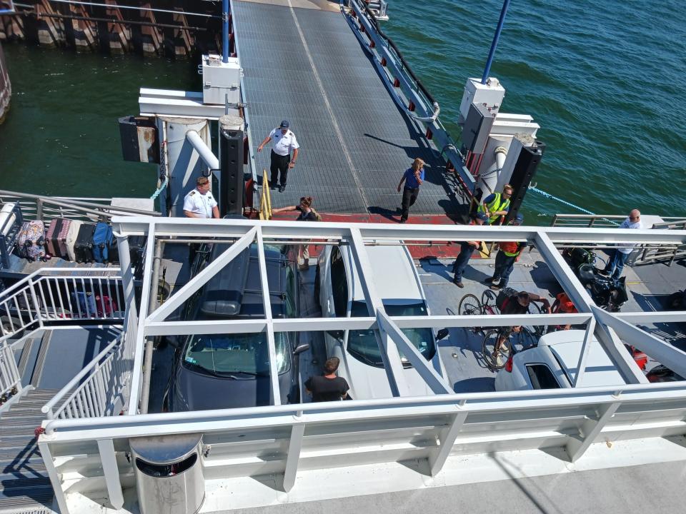 Cars on Lake Express ferry and line of luggage being ushered onto the boat as workers supervise