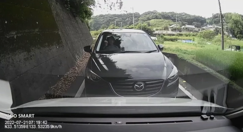 日本網友分享一段行車紀錄畫面，只見兩台車行經狹窄道路，利用「猜拳」來決定誰該讓路。（翻攝推特@YamaMoto3700）