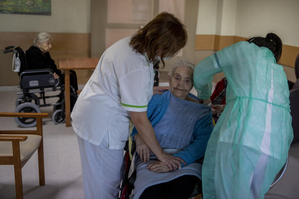 A nurse administers the Pfizer-BioNTech COVID-19 vaccine to a resident at DomusVi nursing home in Leganes, Spain, Wednesday, Jan. 13, 2021. Spain's rate of infection has shot up to 435 cases per 100,000 residents in the past two weeks, prompting new restrictions as authorities try to bring vaccination up to speed. (AP Photo/Manu Fernandez)