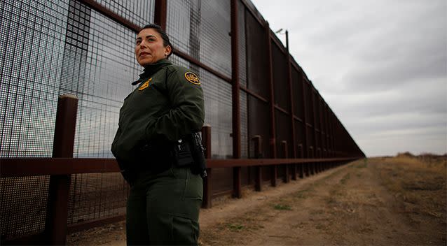 A border guard pictured at a section of the fence that already lines part of the US-Mexico border. Photo: Reuters