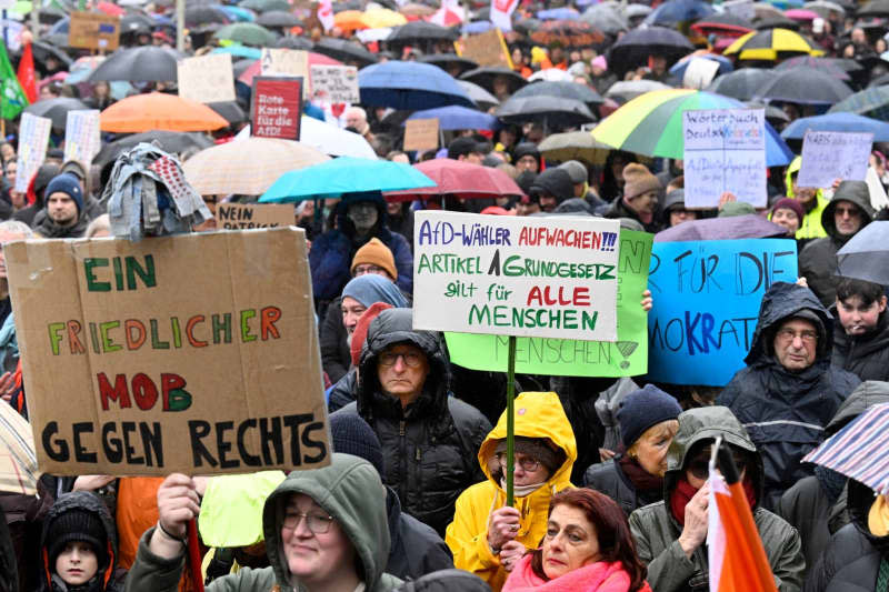 People hold placards and shout slogans during a demonstration against right-wing extremism at Platz der Wiedervereinigung. Roberto Pfeil/dpa