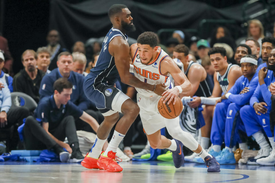 Phoenix Suns guard Devin Booker, right, drives to the basket as Dallas Mavericks forward Tim Hardaway Jr, left, defends during the first half of an NBA basketball game, Sunday, March 5, 2023, in Dallas. (AP Photo/Gareth Patterson)