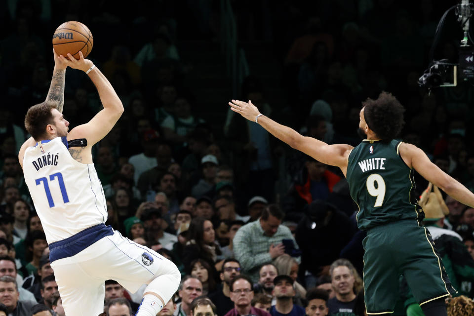 Dallas Mavericks guard Luka Doncic (77) shoots as Boston Celtics guard Derrick White (9) tries to defend during the first half of an NBA basketball game, Wednesday, Nov. 23, 2022, in Boston. (AP Photo/Mary Schwalm)