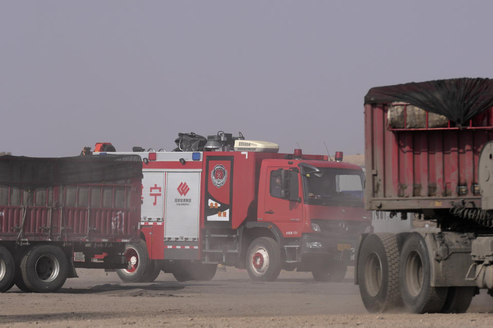 A fire truck drives through a checkpoint along a road in Qingtongxia on northern China's Ningxia Hui Autonomous Region leading to the site of a collapsed open pit mine in Alxa League in northern China's Inner Mongolia Autonomous Region, Friday, Feb. 24, 2023. Rescuers have changed their approach to search for dozens of people missing from a coal mine collapse in northern China to avoid further landslides, state broadcaster CCTV reported Friday. (AP Photo/Ng Han Guan)