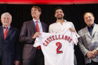 Cincinnati Reds' Nick Castellanos, center right, holds his jersey alongside Reds president and director of operations Dick Williams, center left, CEO Bob Castellini, left, and sports agent Scott Boras, right, during a news conference, Tuesday, Jan. 28, 2020, in Cincinnati. Castellanos signed a $64 million, four-year deal with the baseball club. (AP Photo/John Minchillo)