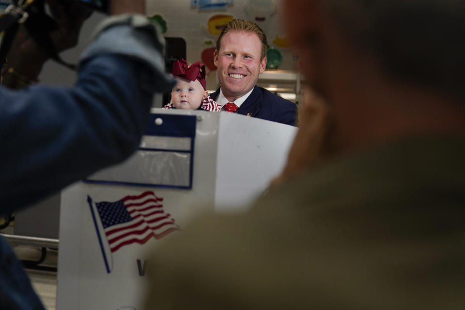 Republican gubernatorial candidate Andrew Giuliani talks to reporters while holding his daughter Grace as he votes in New York, Tuesday, June 28, 2022. New Yorkers are casting votes in a governor's race that for the first time in a decade does not include the name "Cuomo" at the top of the ticket. The most prominent name for Democrats is Kathy Hochul while GOP candidates include Giuliani, the son of New York's former mayor. (AP Photo/Seth Wenig)