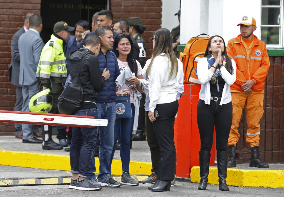 Family members of victims of a bombing gather outside the entrance to the General Santander police academy where the bombing took place in Bogota, Colombia, Thursday, Jan. 17, 2019. (AP Photo/John Wilson Vizcaino)