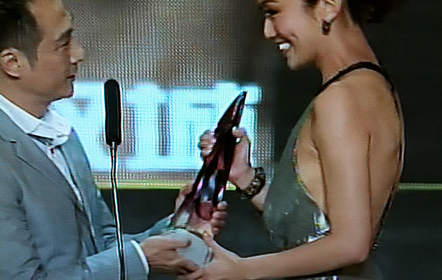 Joanne Peh receives her Best Actress Trophy in a daring backless dress (Youtube Screengrab)