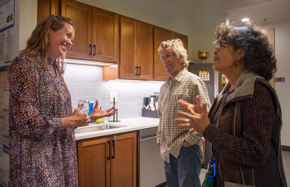 La Directora Ejecutiva de Neighbor to Neighbor, Kelly Evans, conversa con Danny y Lori Feig-Sandoval en la cocina comunitaria del Edificio Comunitario Housing Hub durante su gran inauguración un jueves en Fort Collins.