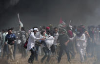 <p>Palestinian medics evacuate a wounded colleague during clashes with Israeli troops along Gaza’s border with Israel, east of Khan Younis, Friday, April 6, 2018. (Photo: Adel Hana/AP) </p>