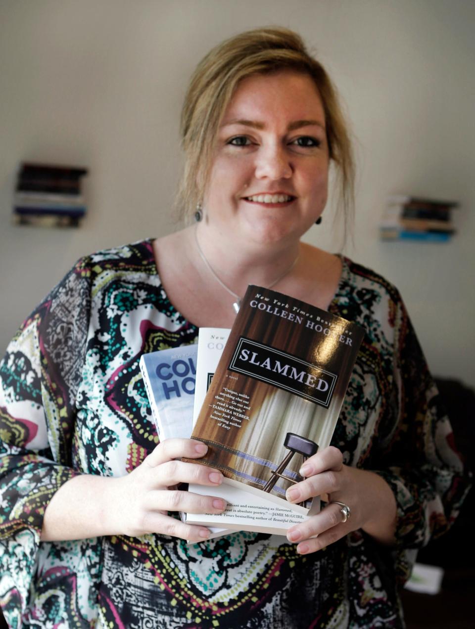 Colleen Hoover holds copies of her books.